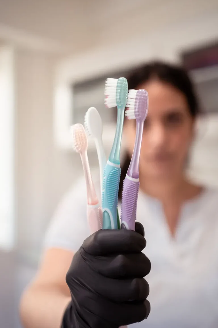 Od. Clara Rossello mostrando cepillos de dientes para higiene oral