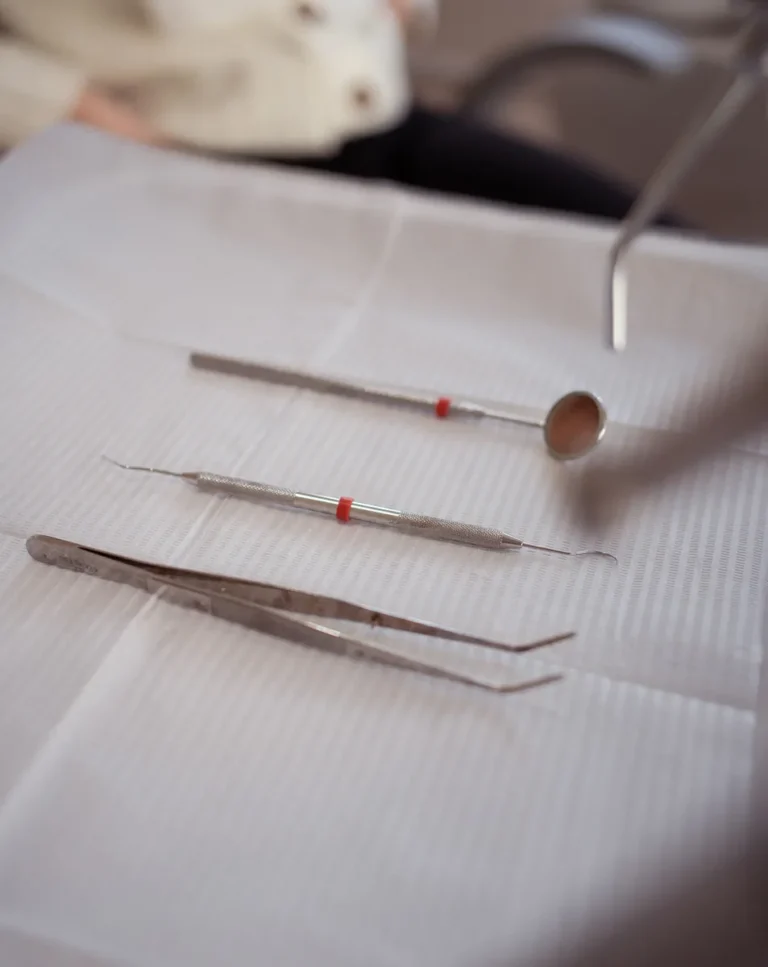 Espejo dental explorador y pinza sobre bandeja de revision