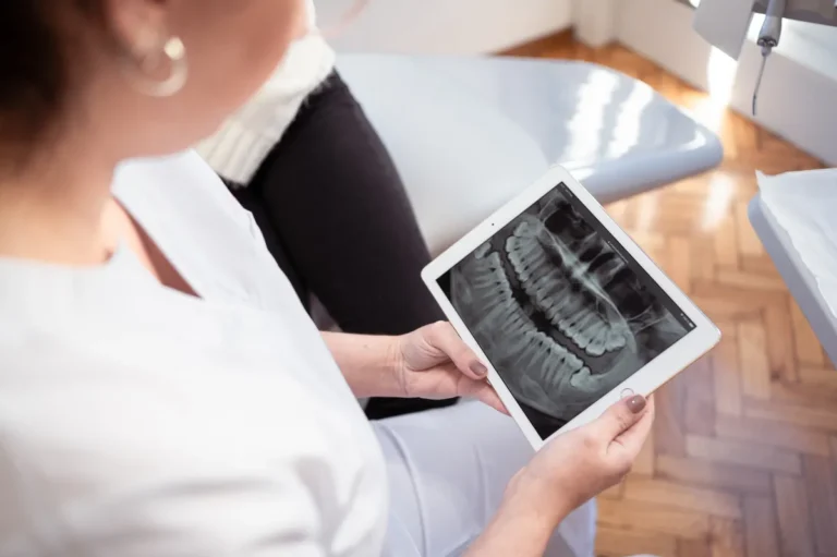 Paciente revisando radiografia panoramica en iPad en consultorio dental